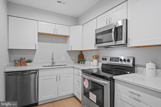 3114 Berry Rd NE Unit 21, Washington, DC 20018 - kitchen with stainless steel appliances, white cabinets, and light stone counters