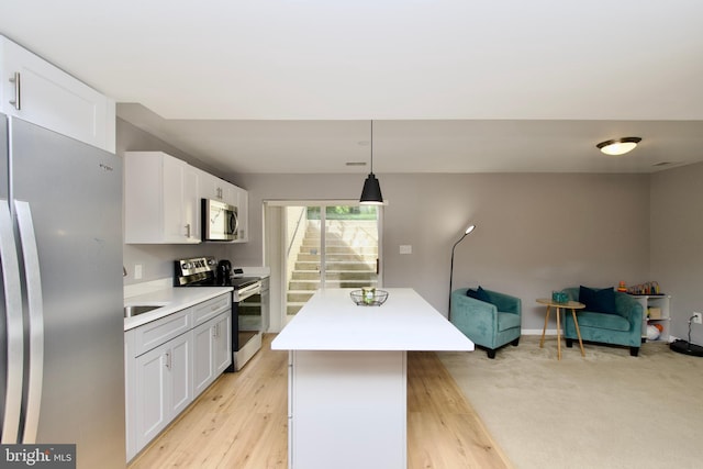 14813 Blackburn Rd, Burtonsville, MD 20866 - kitchen with appliances with stainless steel finishes, a center island, open floor plan, light countertops, and white cabinetry