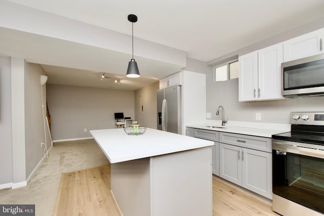 14813 Blackburn Rd, Burtonsville, MD 20866 - kitchen featuring appliances with stainless steel finishes, light countertops, a center island, and hanging light fixtures