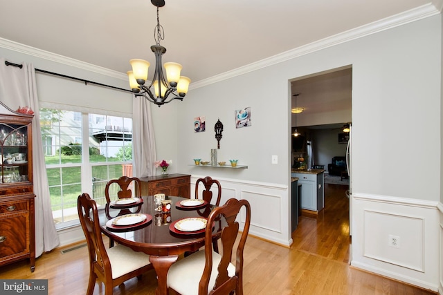 14813 Blackburn Rd, Burtonsville, MD 20866 - dining area with crown molding, a chandelier, plenty of natural light, light wood finished floors, and wainscoting