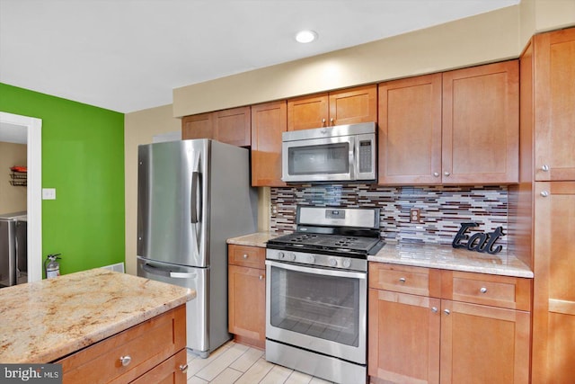 26 Millbank Ln, Voorhees, NJ 08043 - kitchen featuring appliances with stainless steel finishes, backsplash, light stone countertops, and brown cabinets