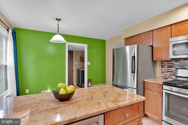 26 Millbank Ln, Voorhees, NJ 08043 - kitchen with stainless steel appliances, decorative backsplash, decorative light fixtures, light stone counters, and brown cabinets