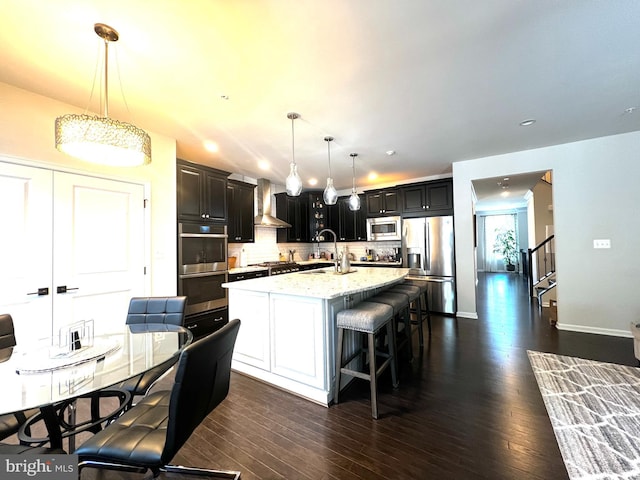 11204 Side Saddle Dr, Upper Marlboro, MD 20772 - kitchen featuring stainless steel appliances, decorative backsplash, a breakfast bar area, a center island with sink, and pendant lighting