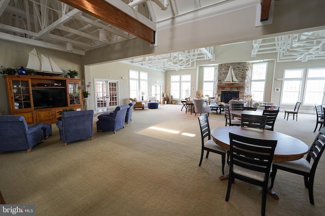 38337 N Mill Ln Unit 116, Ocean View, DE 19970 - carpeted dining space featuring a stone fireplace, healthy amount of natural light, a high ceiling, and beam ceiling