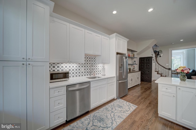 1842 N Capitol St NW, Washington, DC 20002 - kitchen with stainless steel appliances, light countertops, tasteful backsplash, white cabinetry, and wood finished floors