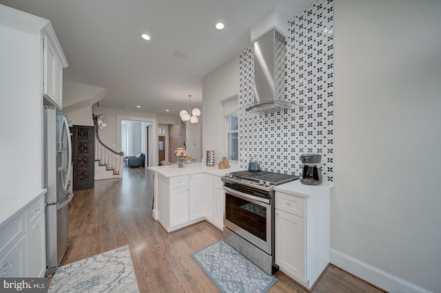 1842 N Capitol St NW, Washington, DC 20002 - kitchen with appliances with stainless steel finishes, wall chimney exhaust hood, a peninsula, white cabinets, and recessed lighting