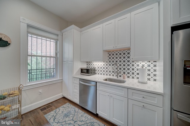 1842 N Capitol St NW, Washington, DC 20002 - kitchen with appliances with stainless steel finishes, white cabinetry, decorative backsplash, and dark wood-style flooring