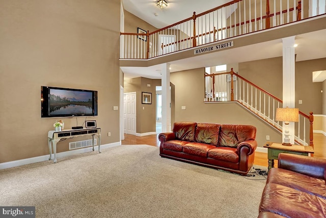 404 Herington Dr, Reading, PA 19608 - carpeted living room featuring stairs, a high ceiling, and decorative columns