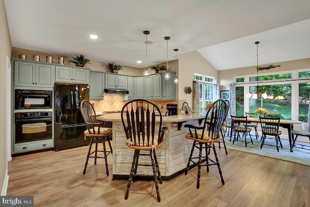 404 Herington Dr, Reading, PA 19608 - kitchen with black appliances, under cabinet range hood, tasteful backsplash, light wood-style floors, and vaulted ceiling