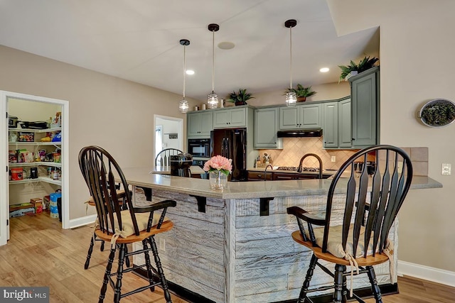 404 Herington Dr, Reading, PA 19608 - kitchen featuring freestanding refrigerator, a kitchen bar, decorative backsplash, light wood-type flooring, and green cabinetry