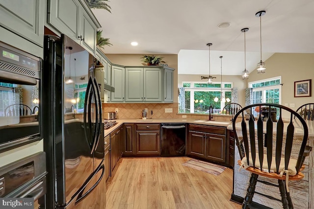 404 Herington Dr, Reading, PA 19608 - kitchen with black appliances, light wood-style flooring, light countertops, decorative backsplash, and decorative light fixtures