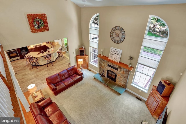 404 Herington Dr, Reading, PA 19608 - carpeted living room featuring plenty of natural light, a high ceiling, a fireplace, and a baseboard radiator