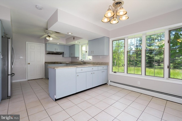 3990 View Top Rd, Ellicott City, MD 21042 - kitchen with under cabinet range hood, a baseboard radiator, freestanding refrigerator, a chandelier, and ceiling fan
