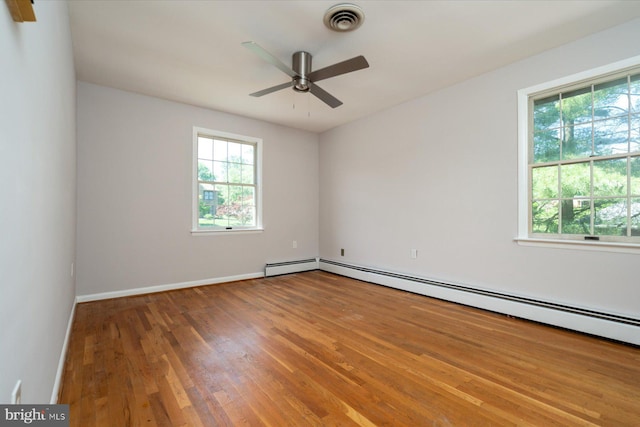 3990 View Top Rd, Ellicott City, MD 21042 - empty room featuring plenty of natural light, wood finished floors, a ceiling fan, and a baseboard heating unit