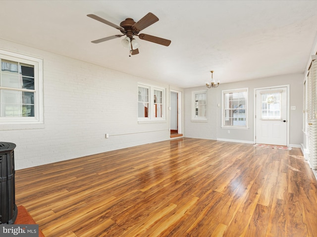 55 W Duck St, Front Royal, VA 22630 - unfurnished living room with brick wall, a chandelier, wood finished floors, ceiling fan, and healthy amount of natural light