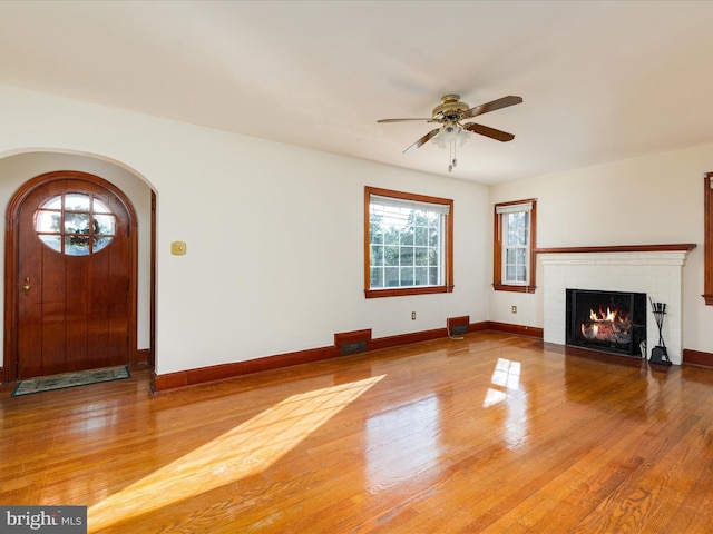 55 W Duck St, Front Royal, VA 22630 - unfurnished living room with arched walkways, a ceiling fan, wood finished floors, and a fireplace