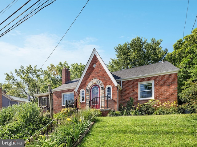 55 W Duck St, Front Royal, VA 22630 - tudor home featuring brick siding, a chimney, a front lawn, and a shingled roof