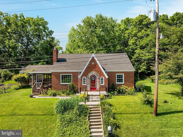 55 W Duck St, Front Royal, VA 22630 - tudor house featuring brick siding, a front lawn, a chimney, and a shingled roof