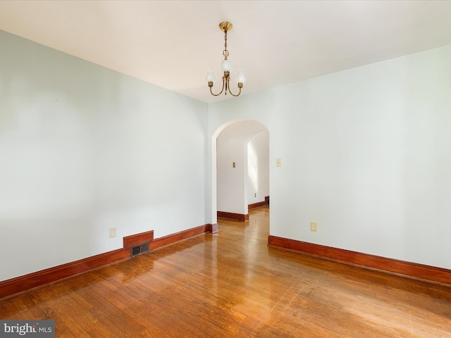 55 W Duck St, Front Royal, VA 22630 - empty room featuring arched walkways, a chandelier, and wood-type flooring
