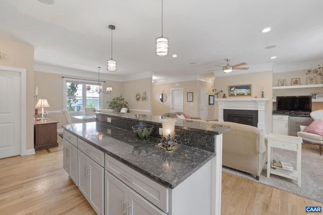 109 Stonecrest Ave, Waynesboro, VA 22980 - kitchen with a ceiling fan, a glass covered fireplace, a center island, ornamental molding, and light wood-type flooring