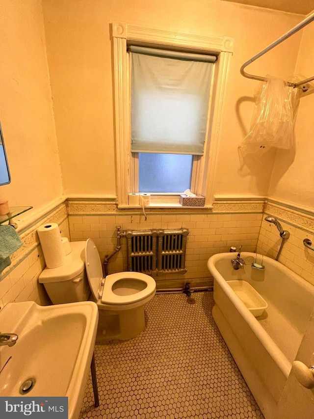 3831 N 19th St, Philadelphia, PA 19140 - full bathroom with radiator, a wainscoted wall, a tub, and tile walls