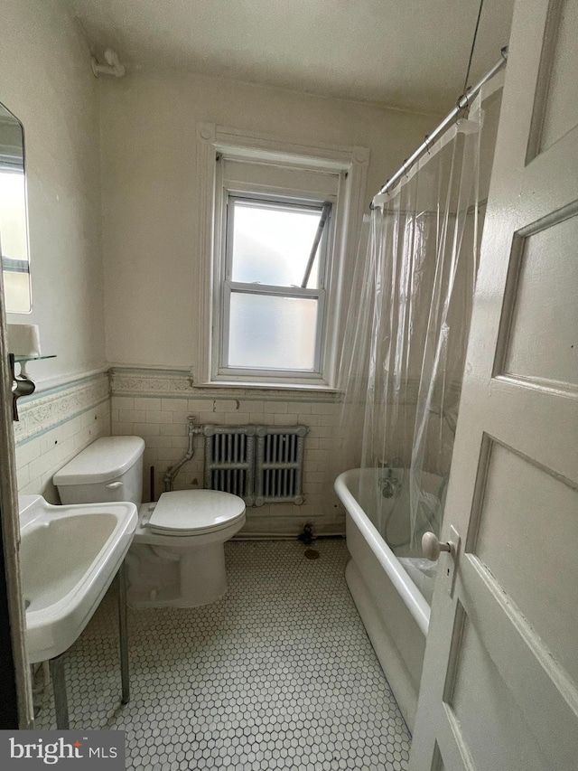 3831 N 19th St, Philadelphia, PA 19140 - bathroom featuring radiator heating unit, tile walls, shower / bath combination with curtain, a wainscoted wall, and tile patterned floors