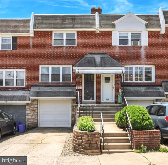 260 Rock St, Philadelphia, PA 19128 - view of property featuring concrete driveway, a garage, brick siding, and stone siding