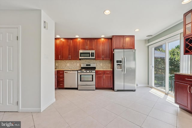 260 Rock St, Philadelphia, PA 19128 - kitchen with stainless steel appliances, backsplash, light tile patterned flooring, recessed lighting, and glass insert cabinets