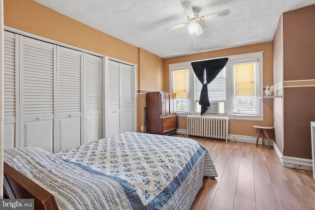 5563 Loretto Ave, Philadelphia, PA 19124 - bedroom with radiator, wood-type flooring, two closets, ceiling fan, and a textured ceiling