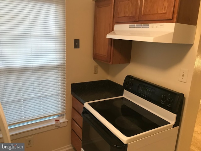 426 Shady Glen Dr, Capitol Heights, MD 20743 - kitchen featuring white electric stove, under cabinet range hood, brown cabinets, and dark countertops