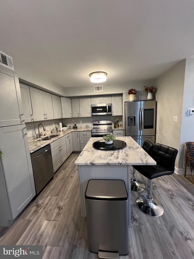 44 Meadowrue Ln, Sicklerville, NJ 08081 - kitchen featuring stainless steel appliances, a kitchen island, dark wood-style flooring, a breakfast bar area, and light stone counters