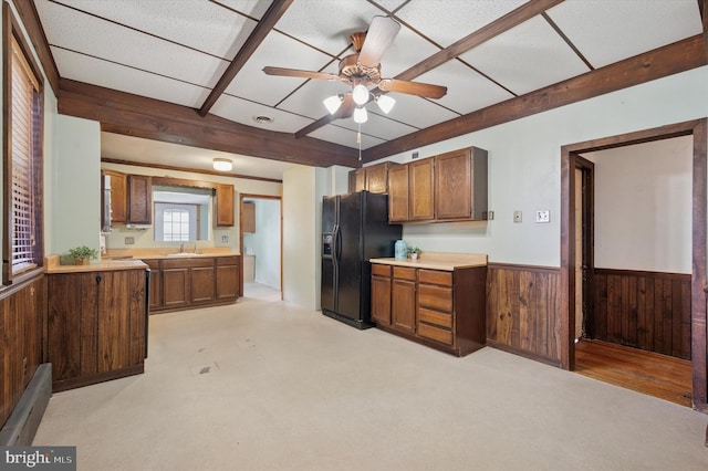 1102 Walnut, Collingdale, PA 19023 - kitchen featuring black refrigerator with ice dispenser, wood walls, light countertops, wainscoting, and a ceiling fan
