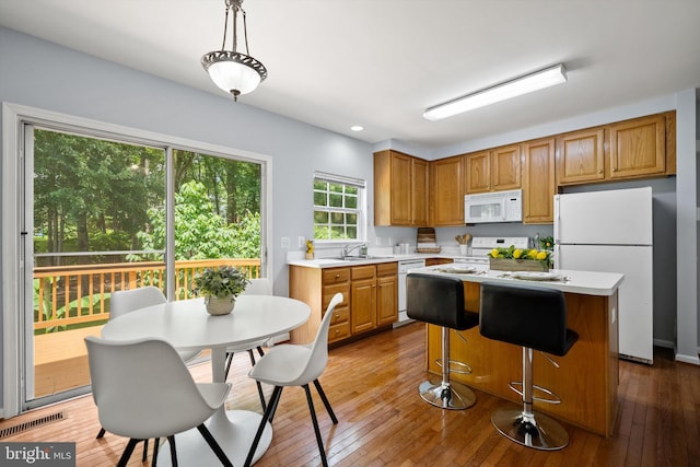 14908 Slippery Elm Ct, Woodbridge, VA 22193 - kitchen with white appliances, light countertops, a center island, hardwood / wood-style floors, and brown cabinetry