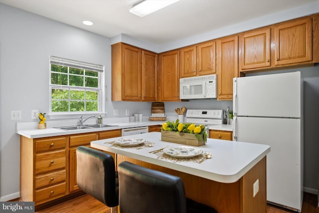 14908 Slippery Elm Ct, Woodbridge, VA 22193 - kitchen featuring white appliances, light countertops, brown cabinets, a center island, and a breakfast bar