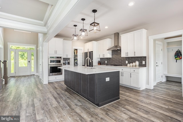 1311 Corbett Rd, Monkton, MD 21111 - kitchen featuring wall chimney exhaust hood, appliances with stainless steel finishes, crown molding, light countertops, and light wood-style floors