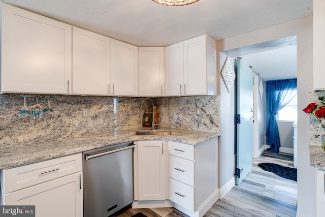 7723 Meath Rd, Baltimore, MD 21222 - kitchen with dishwasher, white cabinets, light wood-type flooring, and tasteful backsplash