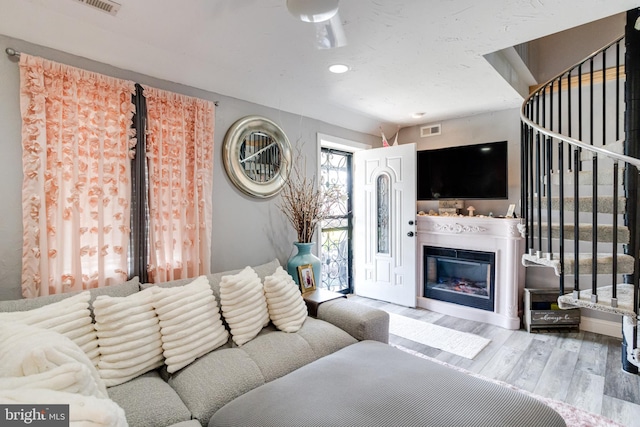 7723 Meath Rd, Baltimore, MD 21222 - living room with wood finished floors, a glass covered fireplace, and recessed lighting