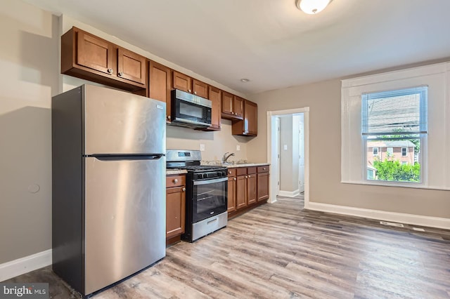2710 The Alameda, Baltimore, MD 21218 - kitchen with appliances with stainless steel finishes, light wood-style floors, brown cabinets, and light countertops