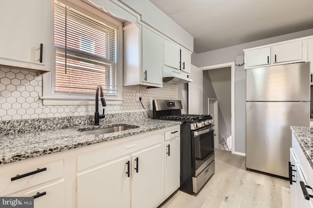 3401 Woodring Ave, Baltimore, MD 21234 - kitchen featuring stainless steel appliances, under cabinet range hood, light wood-style floors, tasteful backsplash, and light stone counters