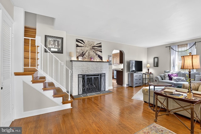 15 Overlook Ave, Lancaster, PA 17601 - living room featuring arched walkways, wood finished floors, a fireplace with raised hearth, and stairway