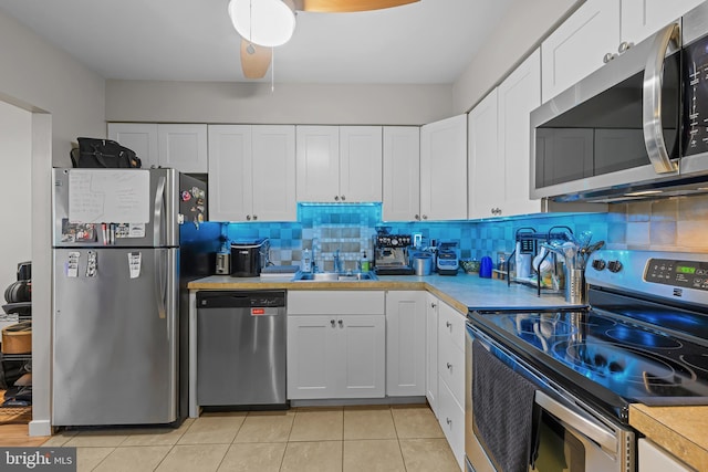 7 Rockford Rd Unit F1, Wilmington, DE 19806 - kitchen featuring stainless steel appliances, light countertops, white cabinets, light tile patterned floors, and decorative backsplash