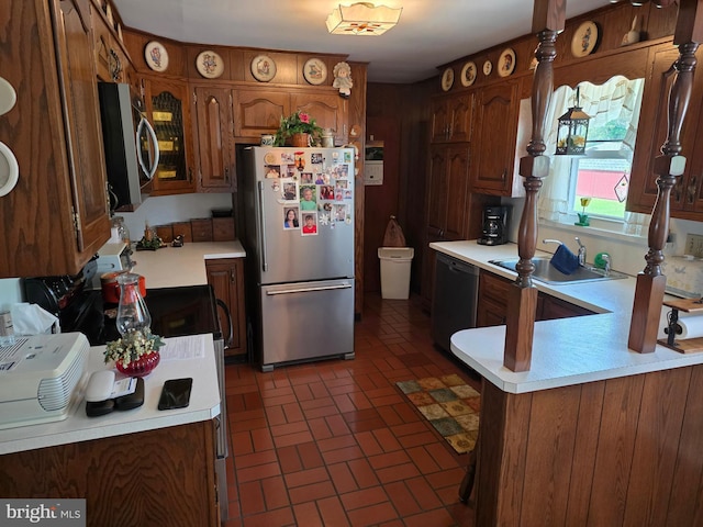 1220 Manatawny St, Pottstown, PA 19464 - kitchen with stainless steel appliances, brick patterned flooring, light countertops, a peninsula, and brown cabinets