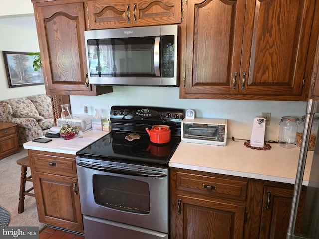 1220 Manatawny St, Pottstown, PA 19464 - kitchen with appliances with stainless steel finishes, light countertops, carpet, and brown cabinetry