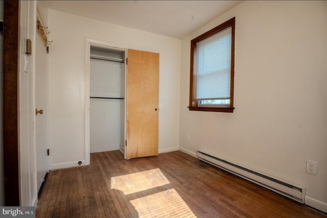 102 Spring St, Bridgeton, NJ 08302 - unfurnished bedroom featuring a baseboard heating unit, wood-type flooring, and a closet