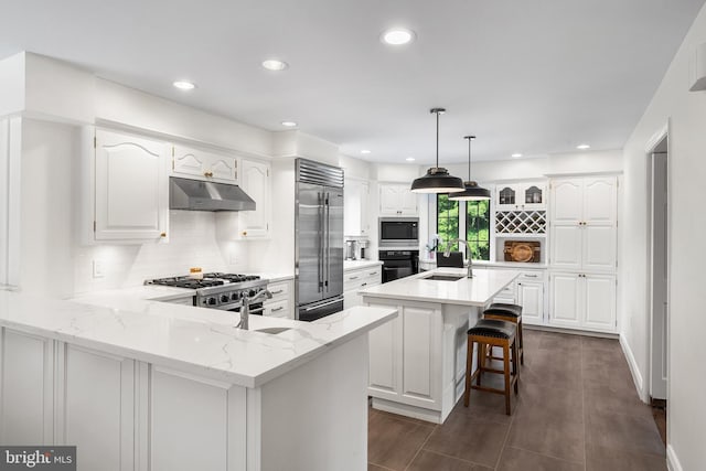 1263 Argyle Rd, Berwyn, PA 19312 - kitchen with built in appliances, under cabinet range hood, a peninsula, backsplash, and recessed lighting