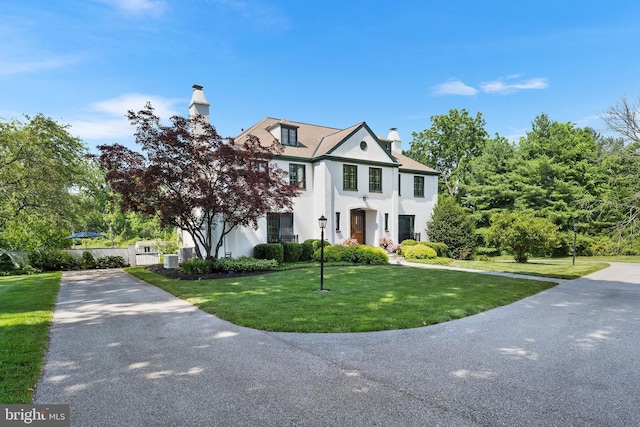 1263 Argyle Rd, Berwyn, PA 19312 - greek revival house with a chimney, stucco siding, a front yard, and driveway