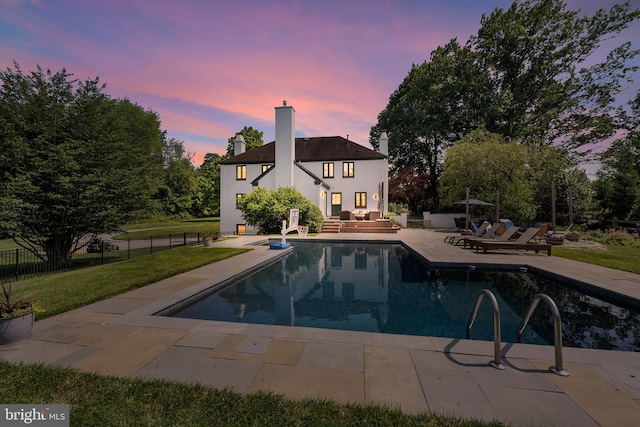 1263 Argyle Rd, Berwyn, PA 19312 - rear view of property featuring a patio, a chimney, an outdoor living space, an outdoor pool, and stucco siding