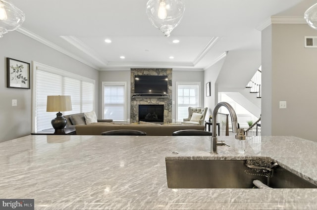 6838 Saint Albans Rd, Mclean, VA 22101 - kitchen with a raised ceiling, a stone fireplace, light stone counters, open floor plan, and ornamental molding