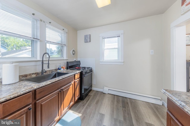 124 E Ormond Ave, Haddon Township, NJ 08107 - kitchen featuring a baseboard radiator, black range with gas cooktop, brown cabinetry, and light wood-style floors