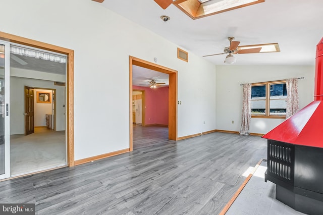 8283 Choptank Rd, Pasadena, MD 21122 - unfurnished living room with a ceiling fan, a skylight, wood finished floors, and lofted ceiling